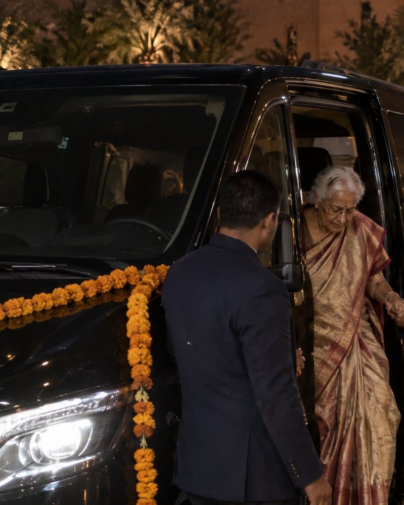 Wedding guests arriving at a Marrakech palace with a fleet of cars and luggage being handled by staff